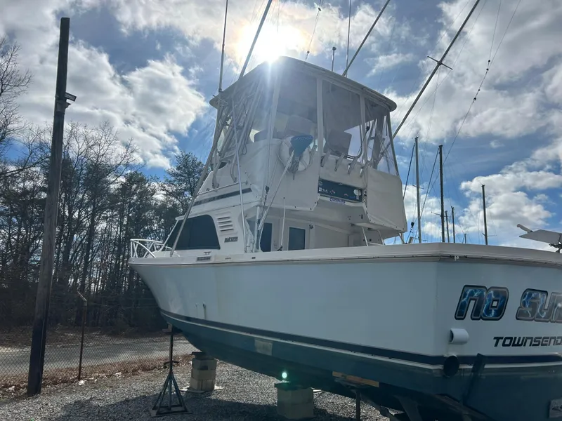 Slide: The Image of 1995 Blackfin 33 Convertible boat on land, under a partly cloudy sky. - 2
