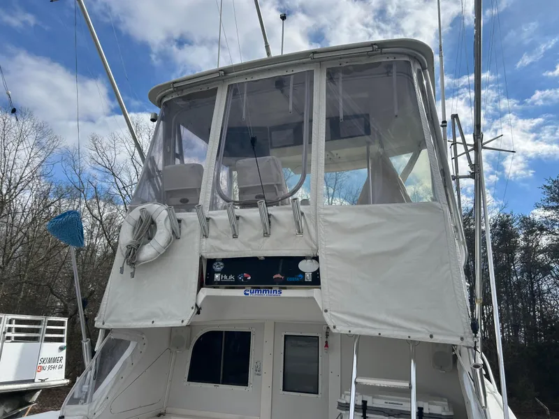 Slide: The Image of 1995 Blackfin 33 Convertible boat with enclosed flybridge, docked outdoors under a cloudy sky. - 20