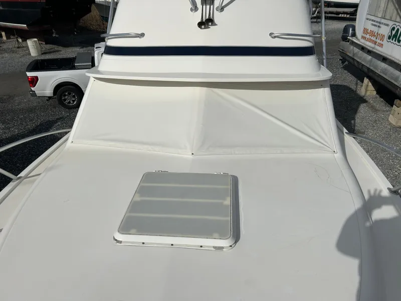 Slide: The Image of 1995 Blackfin 33 Convertible boat deck with hatch, parked on gravel. - 22