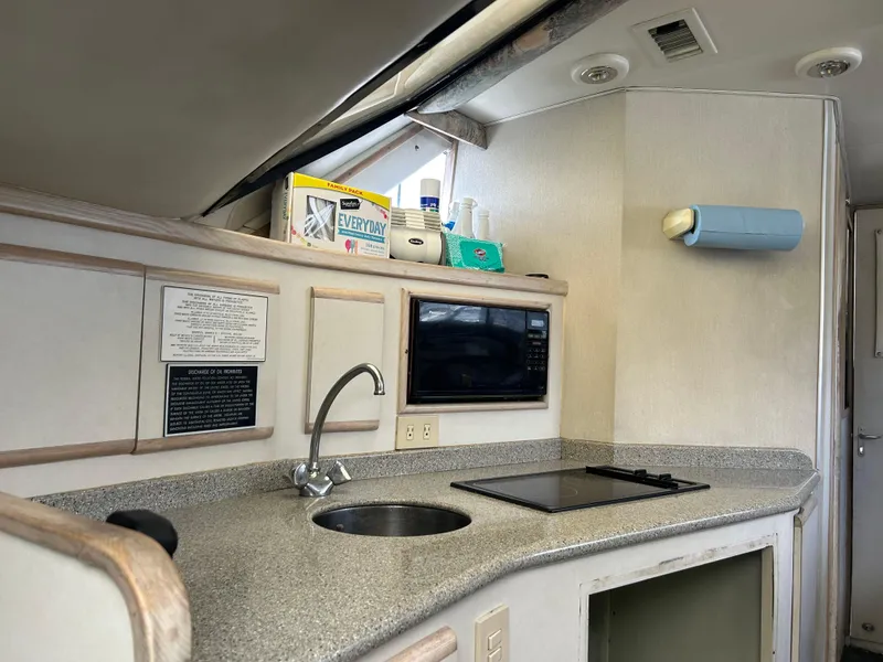 Slide: The Image of 1995 Blackfin 33 Convertible yacht kitchen with sink, microwave, and stove. - 35