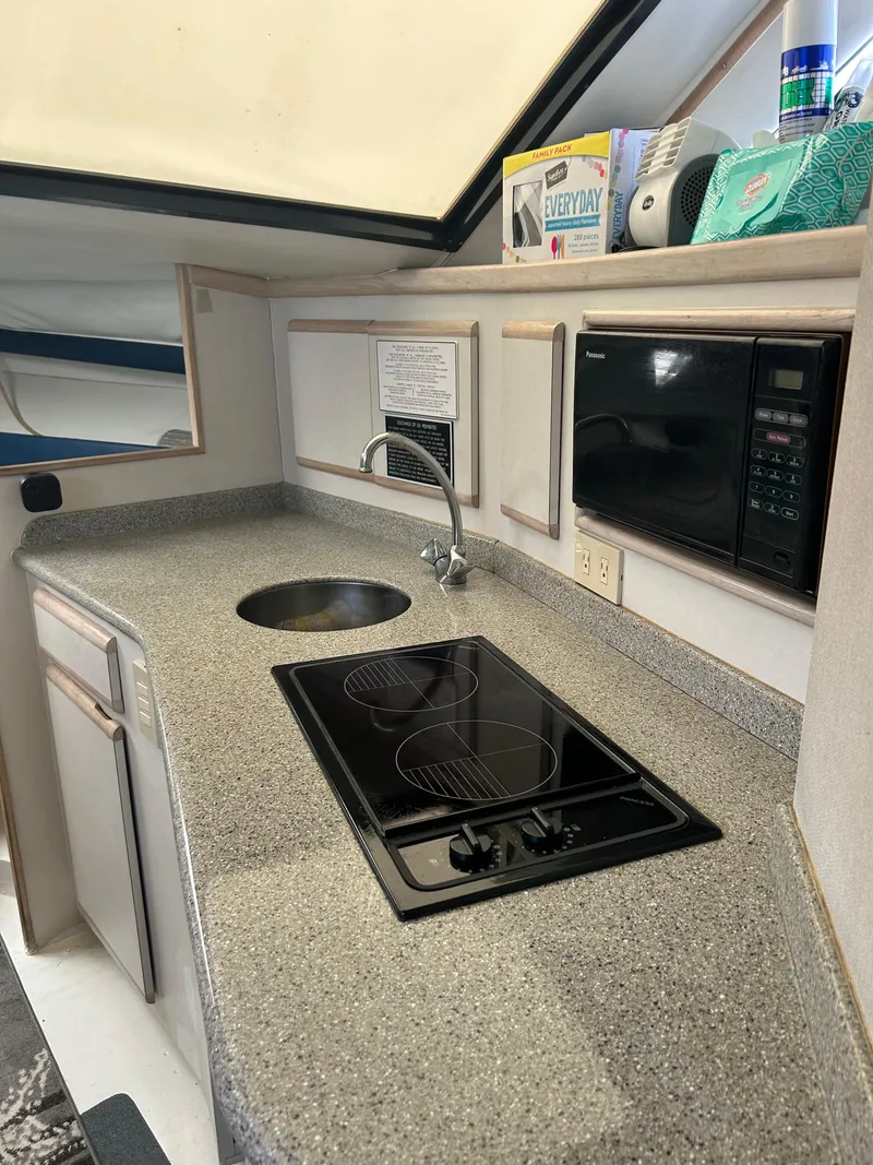 Slide: The Image of 1995 Blackfin 33 Convertible kitchen with stove, sink, and microwave. - 36