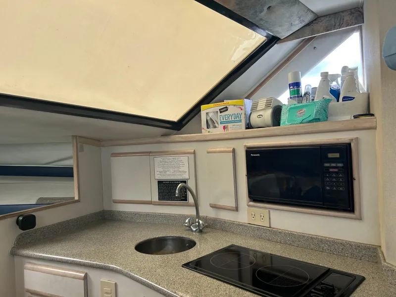 Slide: The Image of Interior of 1995 Blackfin 33 Convertible boat kitchen with sink, stove, and microwave. - 37