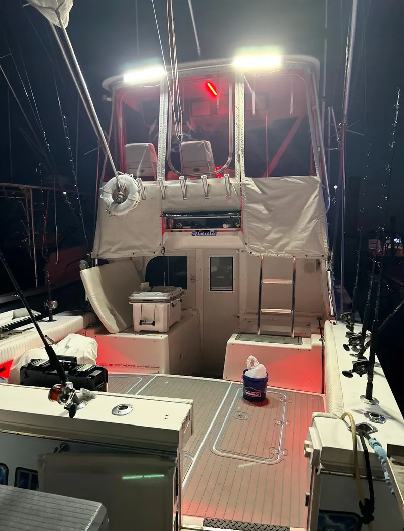 Slide: The Image of 1995 Blackfin 33 Convertible boat with illuminated deck and fishing gear at night. - 47