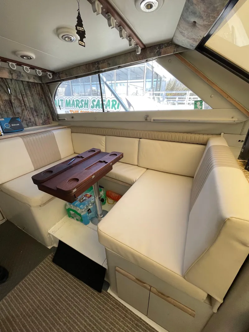 Slide: The Image of 1995 Blackfin 33 Convertible interior with beige seating and wooden table. - 49