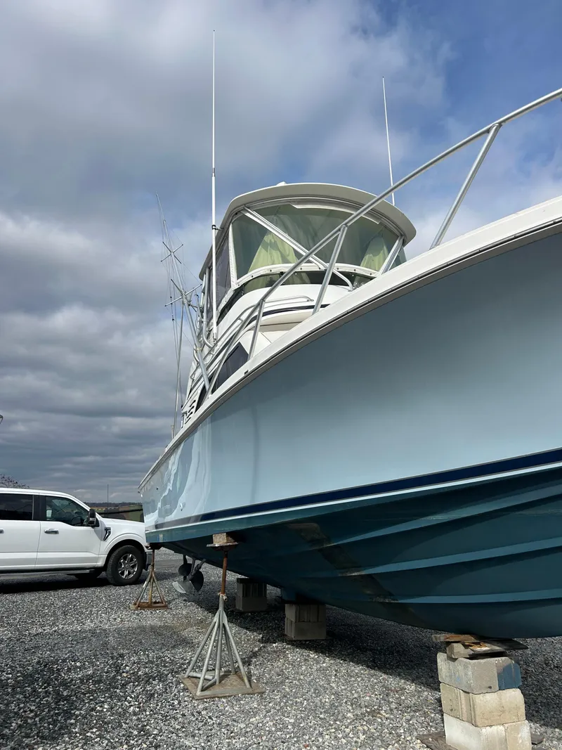 Slide: The Image of 1995 Blackfin 33 Convertible boat on stands, with a cloudy sky background. - 5