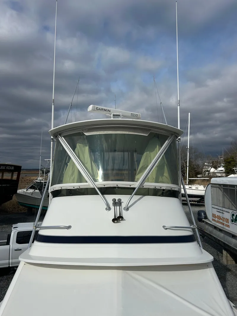 Slide: The Image of 1995 Blackfin 33 Convertible boat with enclosed cabin, docked under cloudy skies. - 6