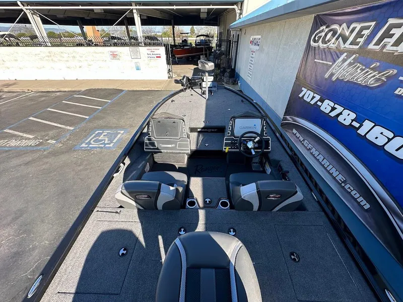 Slide: The Image of 2025 Ranger ALPHA 208 boat interior with seating and control panel in a parking area. - 12