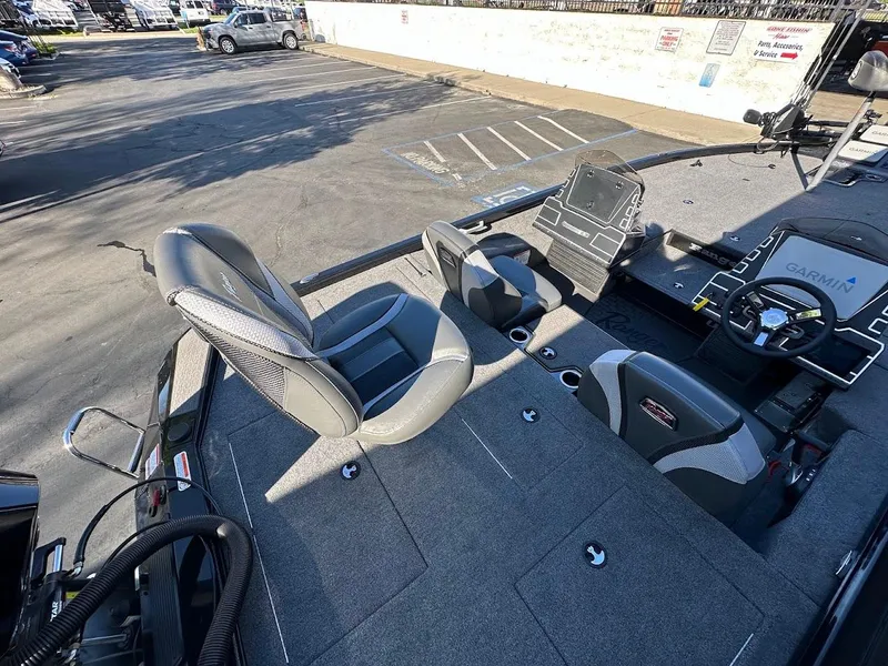 Slide: The Image of 2025 Ranger ALPHA 208 boat interior with seating and control panel in a parking lot. - 13