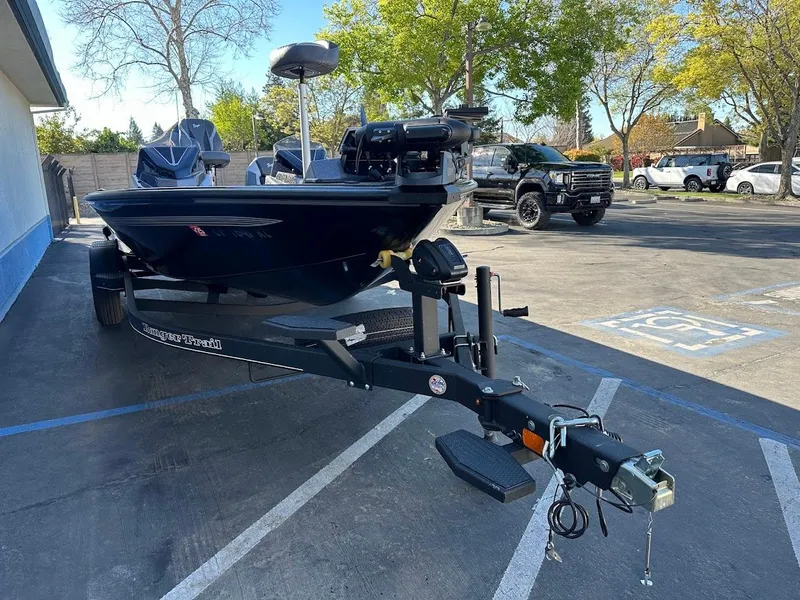 Slide: The Image of 2025 Ranger ALPHA 208 boat on trailer in parking lot, surrounded by trees and vehicles. - 3
