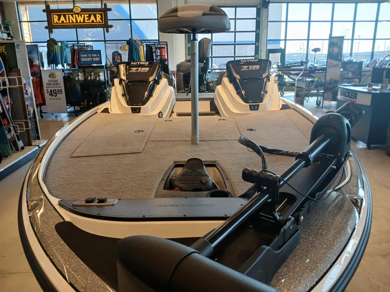 Slide: The Image of 2025 Nitro Z18 boat interior with fishing gear, displayed in a showroom. - 2