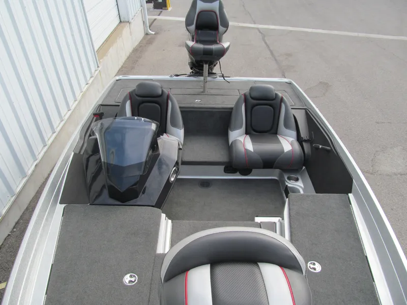 Slide: The Image of 2016 Ranger Z175 boat interior with seating and console, parked on pavement. - 9