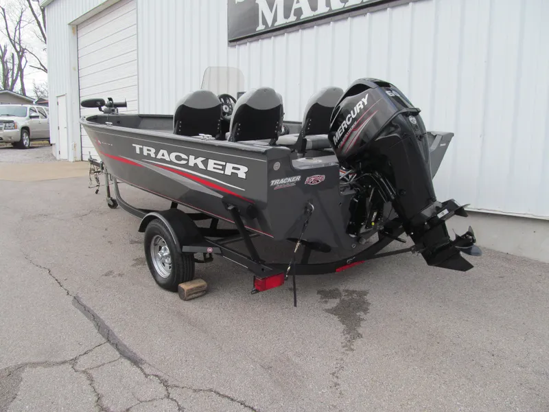 Slide: The Image of 2018 Tracker Pro Guide V-16 SC boat with Mercury engine, parked outside a building. - 3