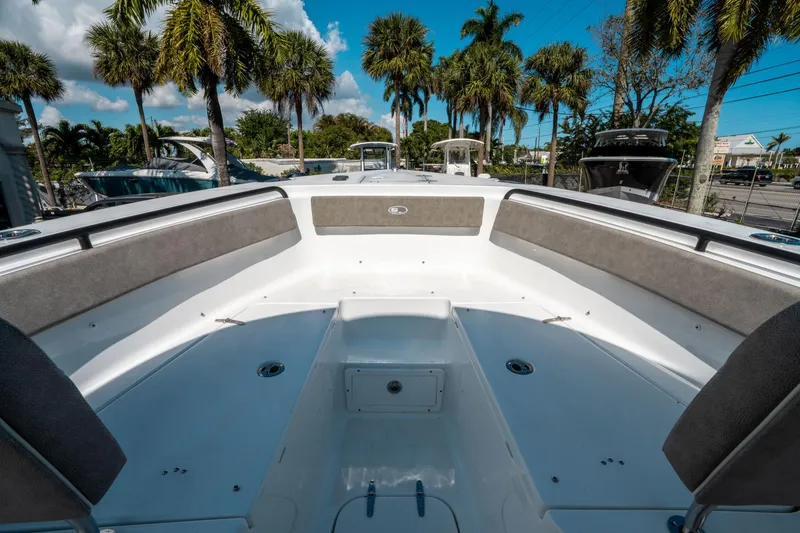 Slide: The Image of 2025 Sea Hunt Gamefish 25 boat interior with seating, surrounded by palm trees. - 34