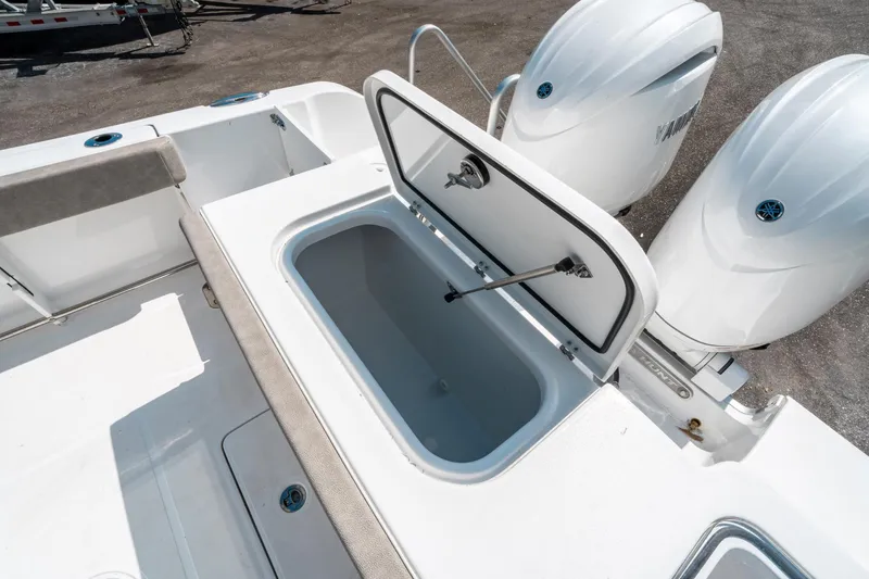 Slide: The Image of 2025 Sea Hunt Gamefish 25 boat with open storage compartment and dual outboard engines. - 13