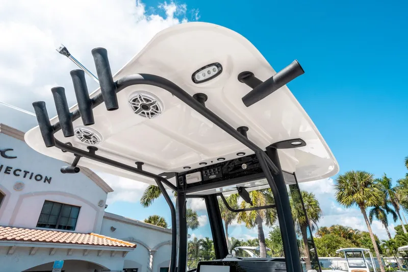 Slide: The Image of 2025 Sea Hunt Gamefish 25 boat top with rod holders and speakers under blue sky. - 18