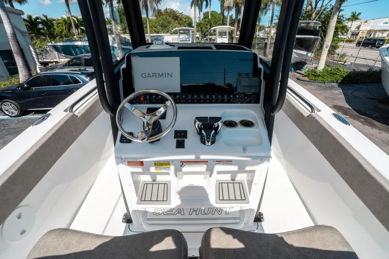 Slide: The Image of 2025 Sea Hunt Gamefish 25 boat console with Garmin navigation system and steering wheel. - 22