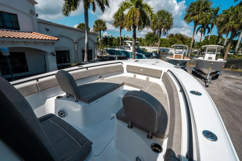 Slide: The Image of 2025 Sea Hunt Gamefish 25 boat interior with seating, parked outdoors under palm trees. - 31