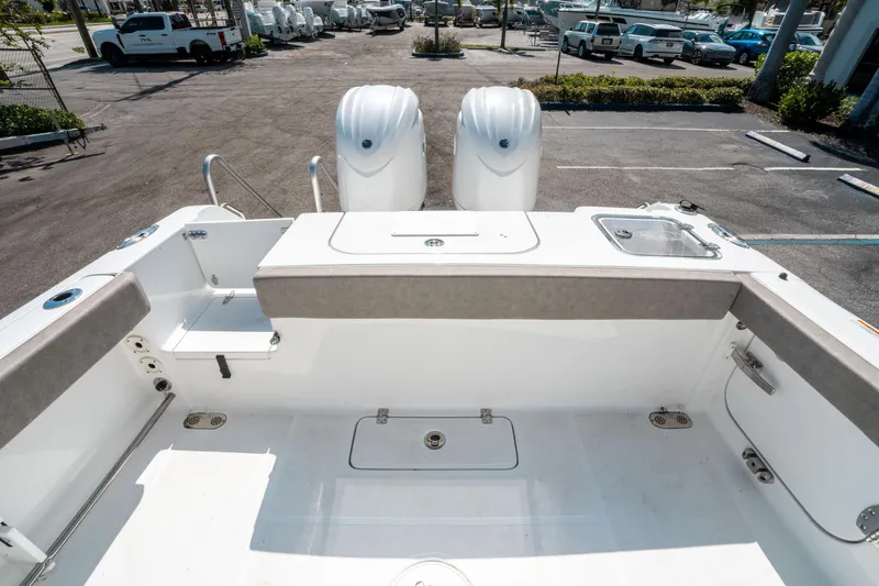 Slide: The Image of 2025 Sea Hunt Gamefish 25 boat interior with dual engines in a parking lot. - 10