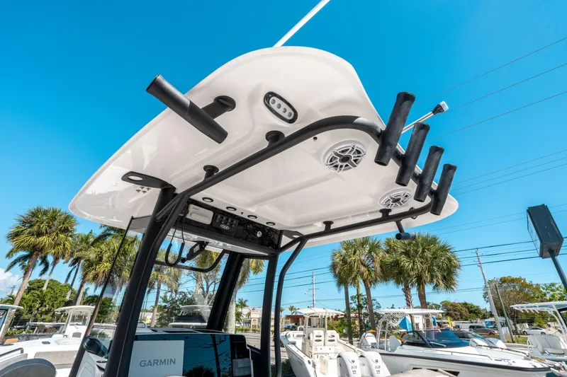 Slide: The Image of 2025 Sea Hunt Gamefish 25 boat with rod holders and speakers, under clear blue sky. - 19