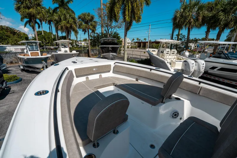 Slide: The Image of 2025 Sea Hunt Gamefish 25 boat interior with seating, surrounded by palm trees. - 30