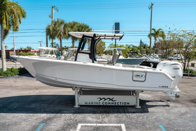 Slide: The Image of 2025 Sea Hunt Gamefish 25 boat displayed outdoors at Marine Connection dealership. - 5