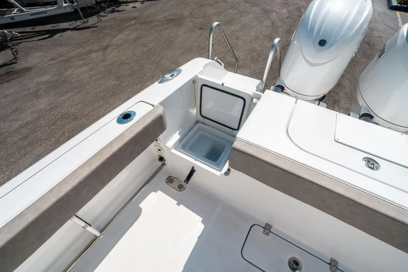 Slide: The Image of 2025 Sea Hunt Gamefish 25 boat interior with open storage compartment and dual engines. - 15