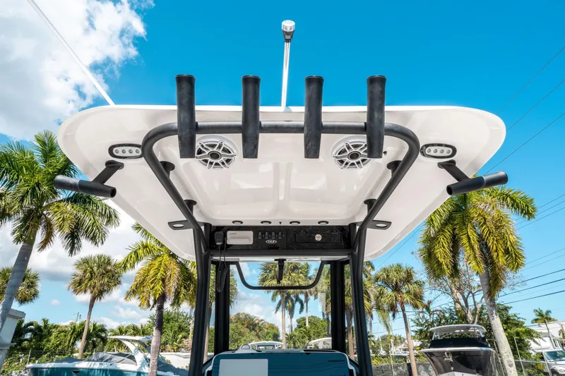 Slide: The Image of 2025 Sea Hunt Gamefish 25 boat with rod holders and speakers, under a clear blue sky. - 17