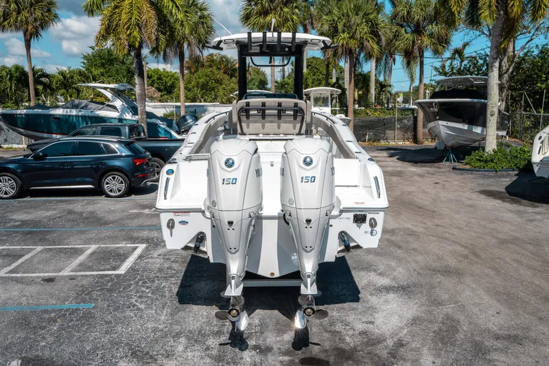 Slide: The Image of 2025 Sea Hunt Gamefish 25 with dual Yamaha 150 engines, parked outdoors near palm trees. - 3