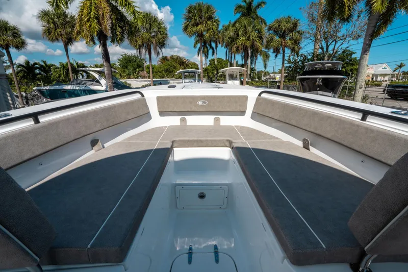 Slide: The Image of 2025 Sea Hunt Gamefish 25 boat interior with cushioned seating and palm trees in the background. - 32