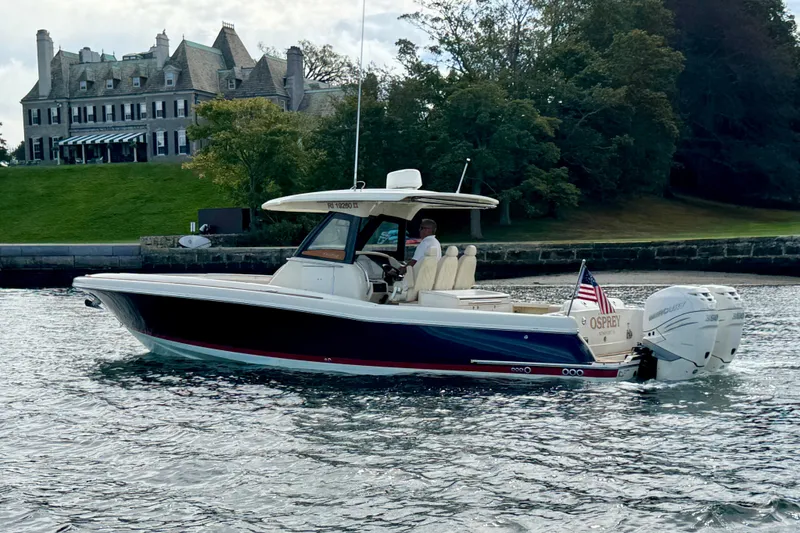Slide: The Image of 2019 Chris-Craft Catalina 34 boat cruising near a historic mansion on a scenic waterway. - 21
