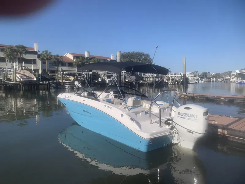 Slide: The Image of 2025 Hurricane SD 2050 boat docked in a marina with Suzuki outboard motor. - 2