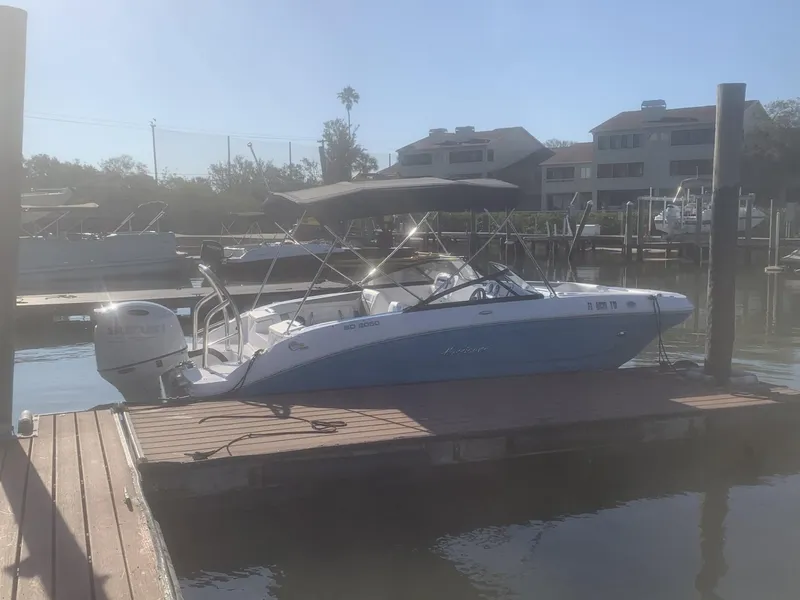 Slide: The Image of 2025 Hurricane SD 2050 boat docked at marina with canopy and outboard motor. - 24