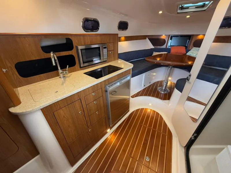 Slide: The Image of 2011 Pursuit OS 345 Offshore boat interior with plush seating and modern helm. - 12