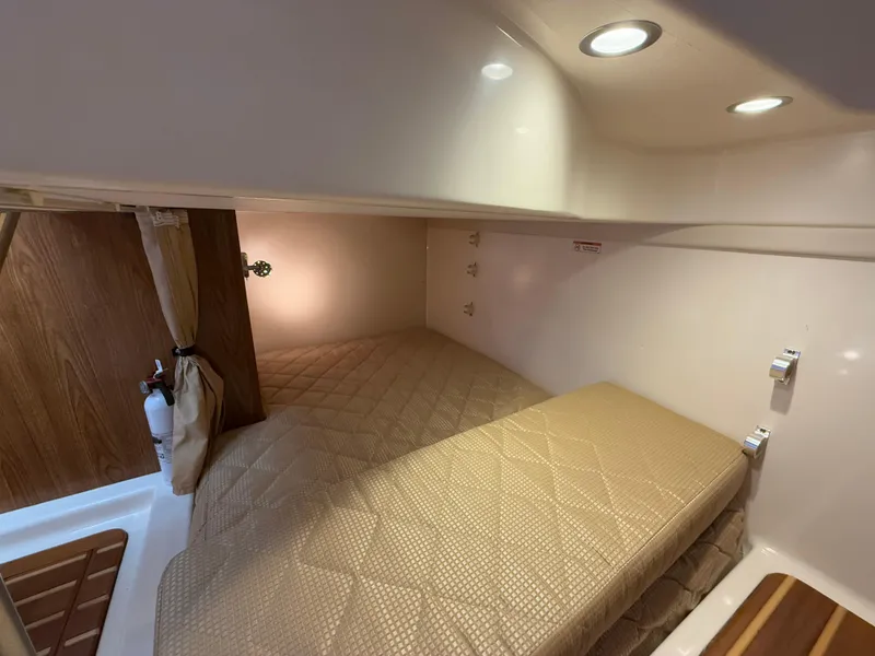 Slide: The Image of 2011 Pursuit OS 345 Offshore galley with wood cabinetry, sink, microwave, and cooktop. - 19