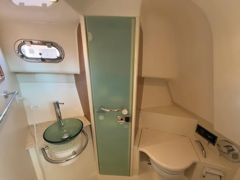 Slide: The Image of 2011 Pursuit OS 345 Offshore cabin interior with wood cabinets and cushioned seating. - 20