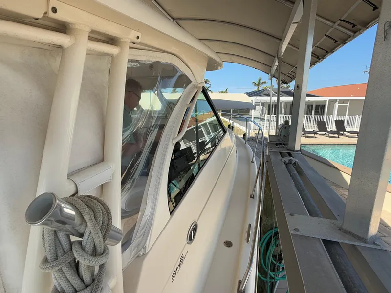 Slide: The Image of Interior view of 2011 Pursuit OS 345 Offshore boat with seating and windows overlooking marina. - 26