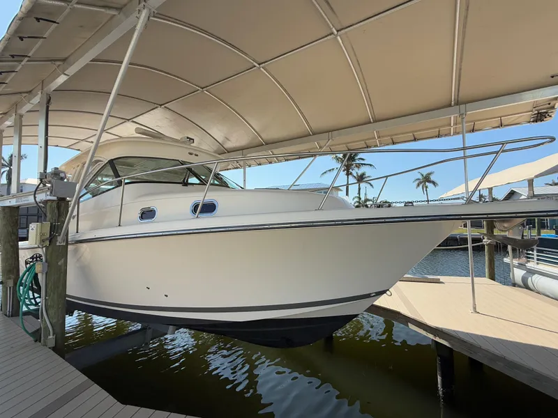 Slide: The Image of 2011 Pursuit OS 345 Offshore boat docked under a canopy. - 3