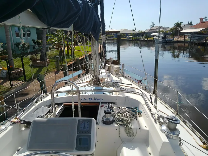 Slide: The Image of Hunter Passage 42 sailboat from 1990 docked in a serene canal setting. - 11