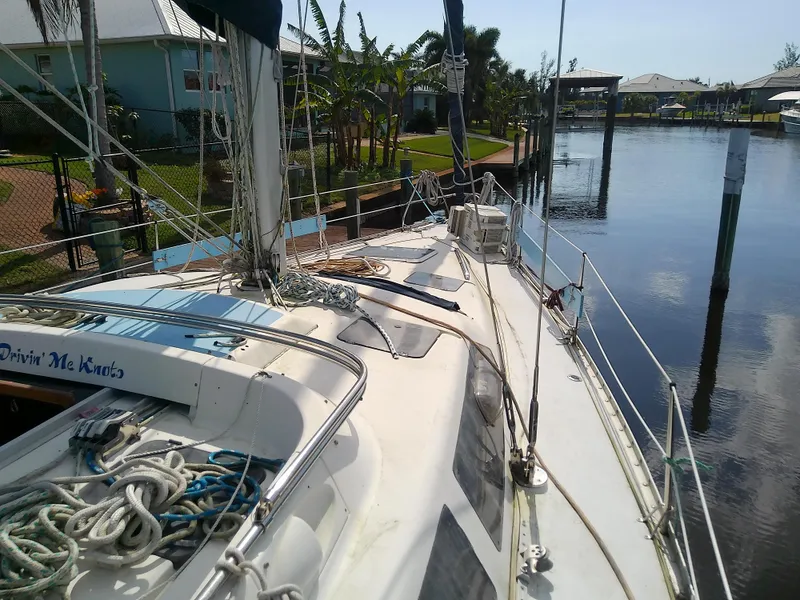 Slide: The Image of 1990 Hunter Passage 42 sailboat docked in a serene canal setting. - 14