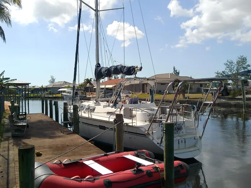 Slide: The Image of 1990 Hunter Passage 42 sailboat docked beside a red inflatable boat. - 2