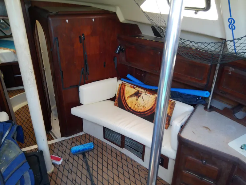 Slide: The Image of Interior of 1990 Hunter Passage 42 sailboat with wooden cabinets and white seating. - 27