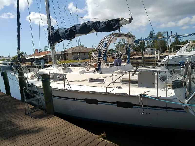 Slide: The Image of 1990 Hunter Passage 42 sailboat docked at marina under blue sky. - 3