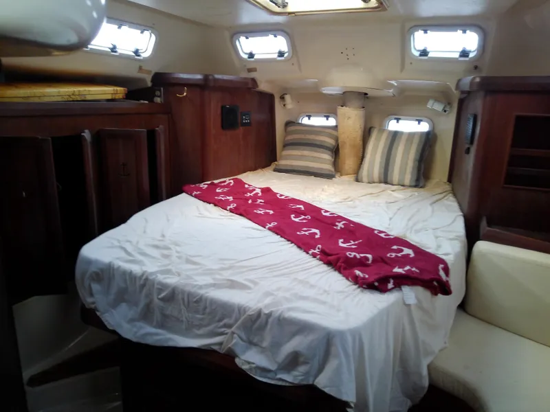 Slide: The Image of Cozy cabin interior of 1990 Hunter Passage 42 sailboat with bed and portholes. - 41
