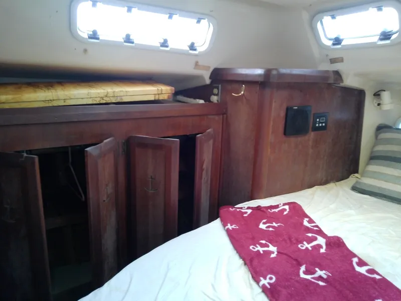 Slide: The Image of Interior cabin of 1990 Hunter Passage 42 sailboat with wooden cabinets and bedding. - 44