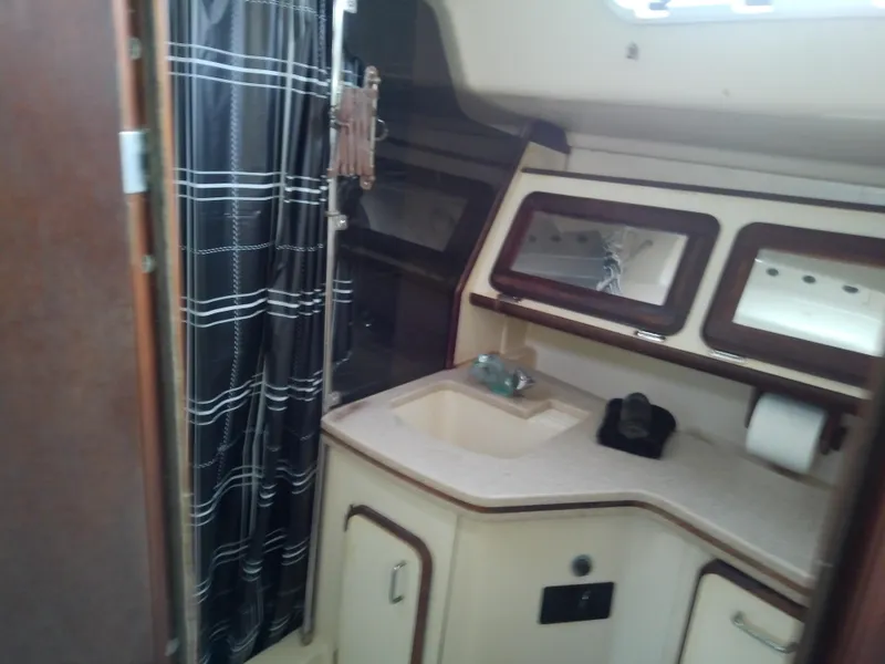 Slide: The Image of Interior of 1990 Hunter Passage 42 yacht bathroom with sink and shower curtain. - 45
