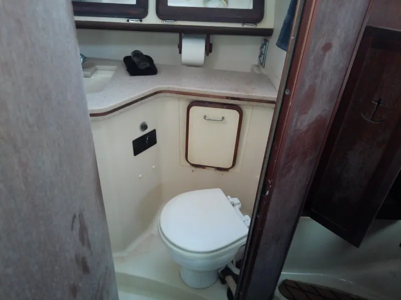 Slide: The Image of 1990 Hunter Passage 42 yacht bathroom with toilet, sink, and storage cabinet. - 46