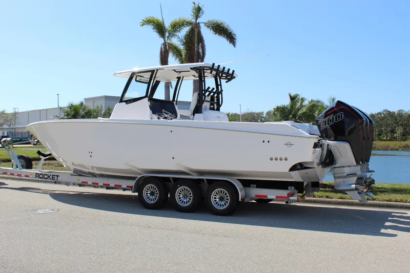 Slide: The Image of 2024 Fountain 32 NX boat on trailer, parked near palm trees. - 11