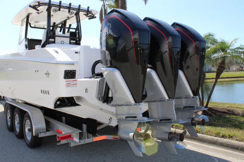 Slide: The Image of 2024 Fountain 32 NX boat with triple outboard engines on a trailer. - 23