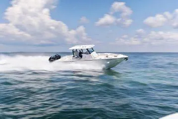 Slide: The Image of 2024 Fountain 32 NX speedboat cruising on open water under a clear sky. - 25