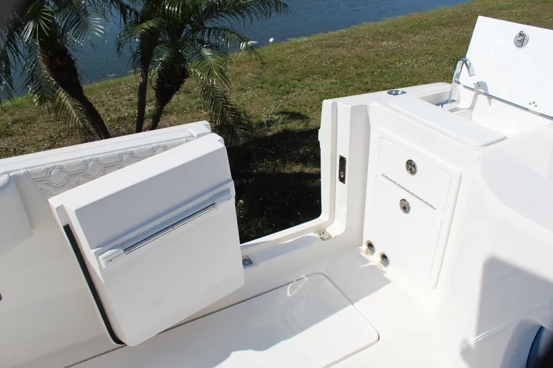 Slide: The Image of 2024 Fountain 32 NX boat interior with storage compartments and seating near water. - 34